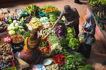 Vibrant local vegetable market scene with vendors and fresh produce